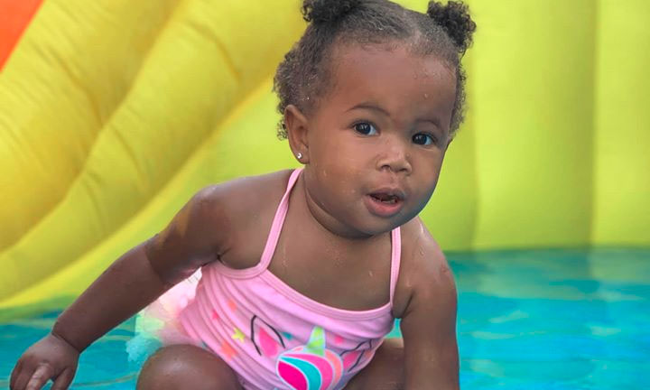 A cute african american toddler girl wearing a pink unicorn outfit at a Preschool & Daycare Serving Hampton Roads, VA