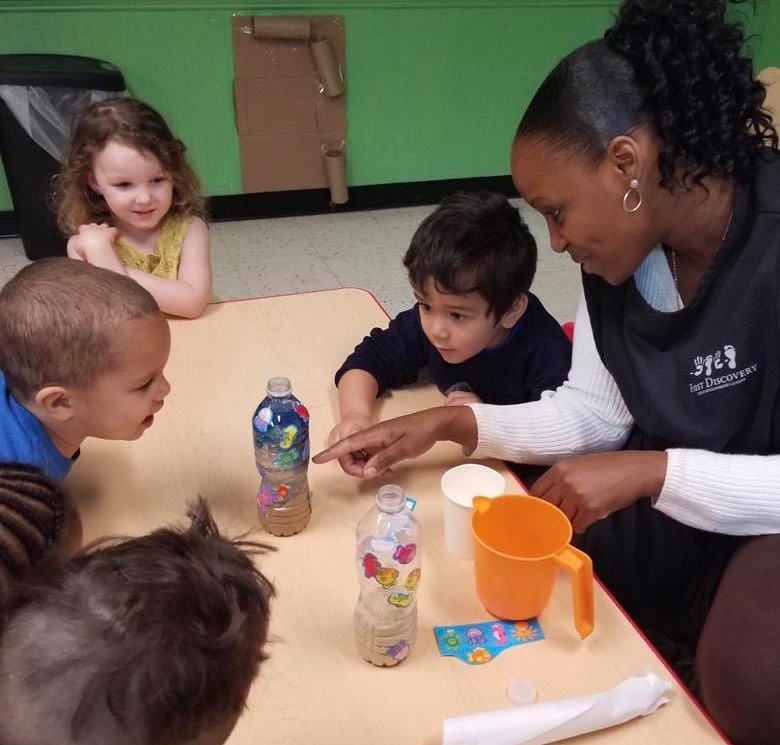 Preschoolers getting amazed with their teacher on a sand in a bottle activity at a Preschool & Daycare Serving Hampton Roads, VA