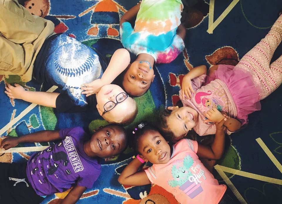 Group of preschool kids very happy and lying around at a Preschool & Daycare Serving Hampton Roads, VA