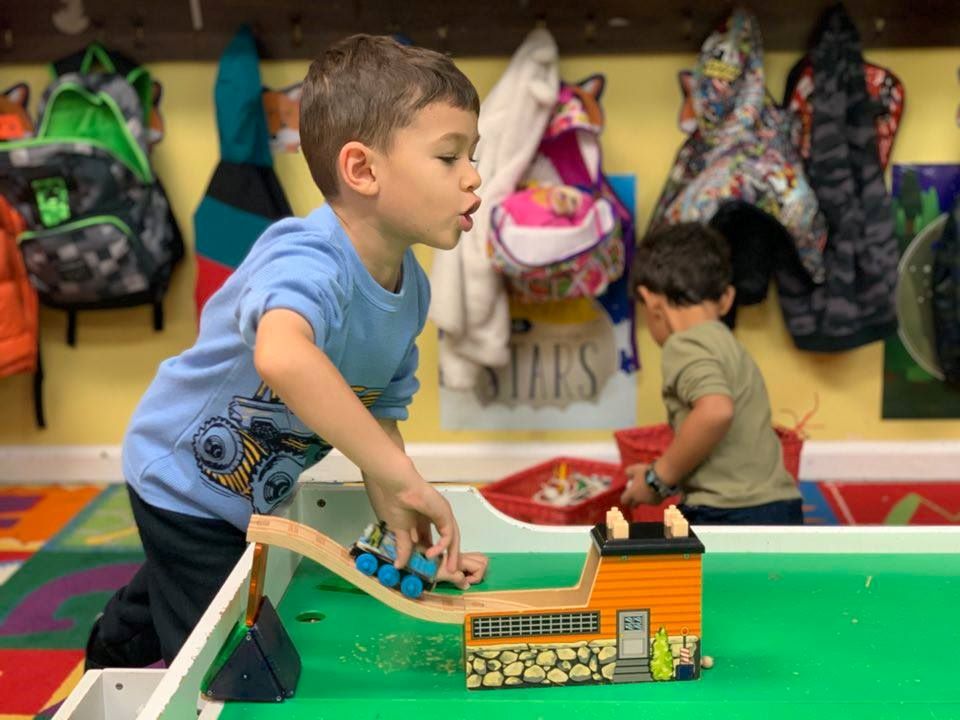 A young boy having fun playing a train toy at a Preschool & Daycare Serving Hampton Roads, VA