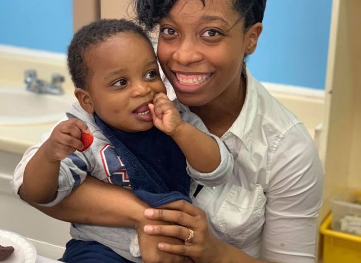 Happy african american mother and cute toddler son while eating strawberry at a Preschool & Daycare Serving Hampton Roads, VA