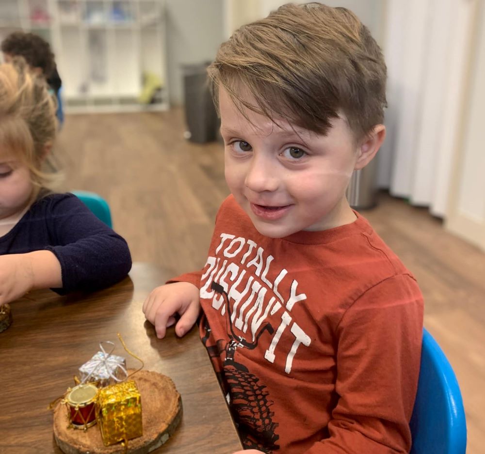 Happy little young boy crafting a small Christmas ornament on a holiday art decor activity at a Preschool & Daycare Serving Hampton Roads, VA