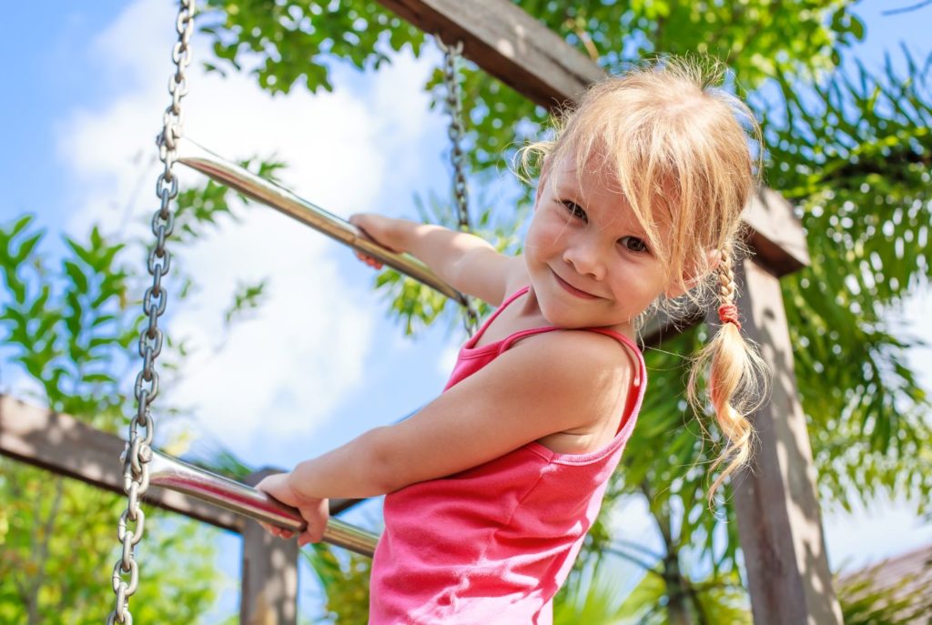 Cute little girl climbing on a chain ladder at a Preschool & Daycare Serving Hampton Roads, VA