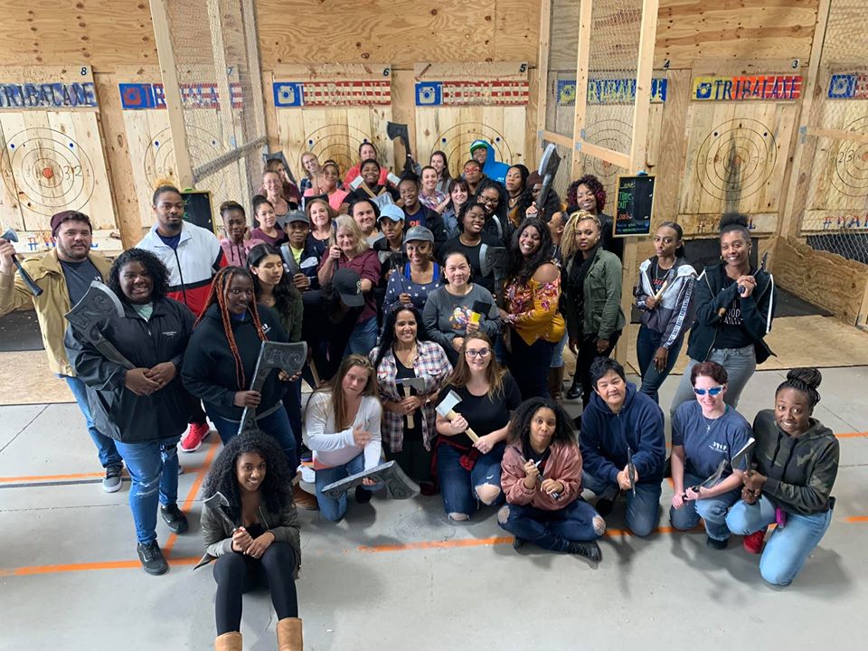 Teachers and parents gather around to do a group selfie while holding their Axe props at a Preschool & Daycare Serving Hampton Roads, VA