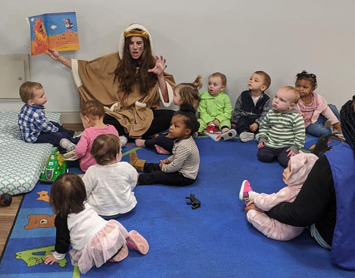 Teacher wearing an animal props doing a story telling to a group of toddlers at a Preschool & Daycare Serving Hampton Roads, VA